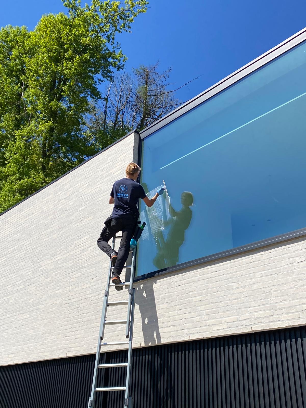 Aaron reinigt grote glasgevel van moderne villa